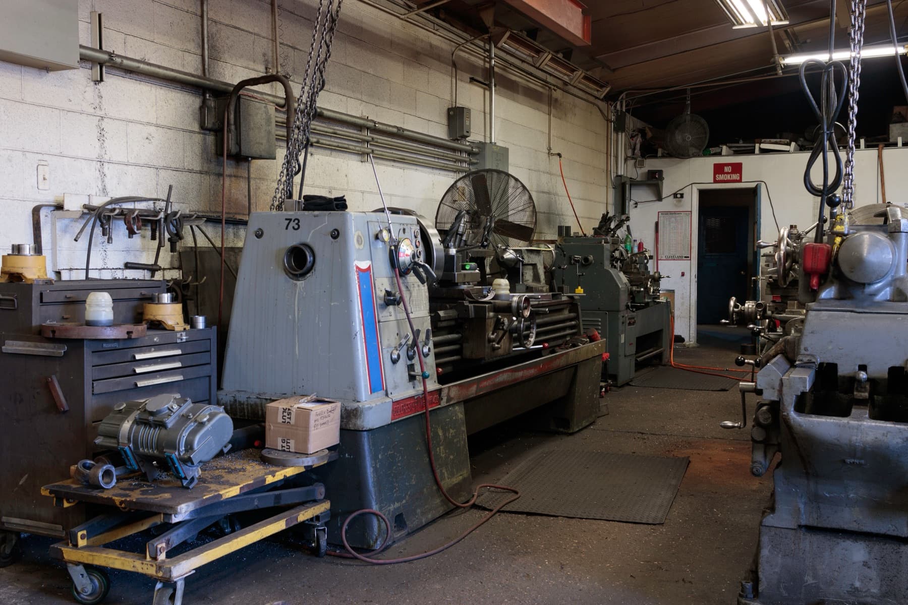 A machine shop with lathes and tooling along the wall